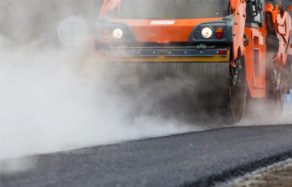 A truck driving down the road with smoke coming out of it.