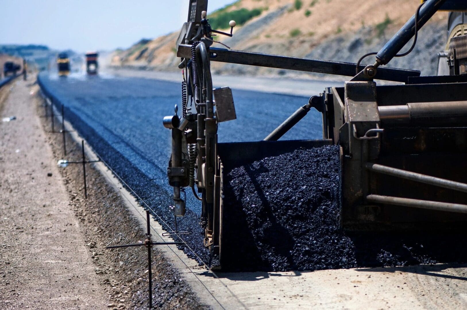 A truck is driving down the road with blue gravel.